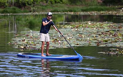 Student kayaking in water on campus.